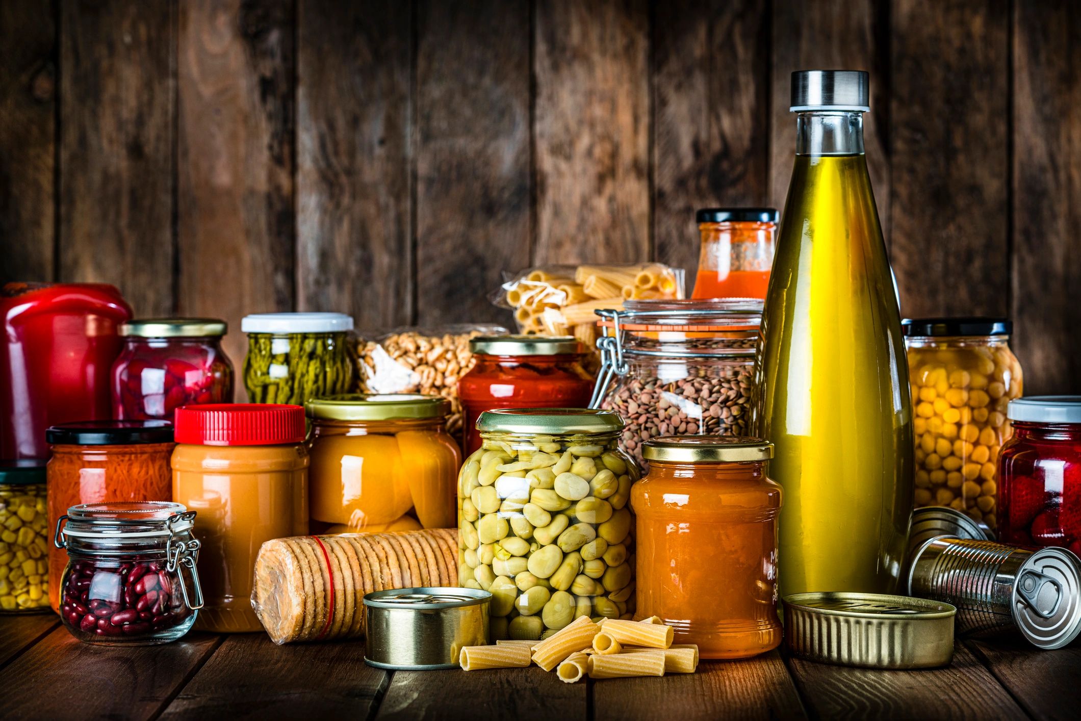 Assorted pantry staples and preserves on a rustic wooden table