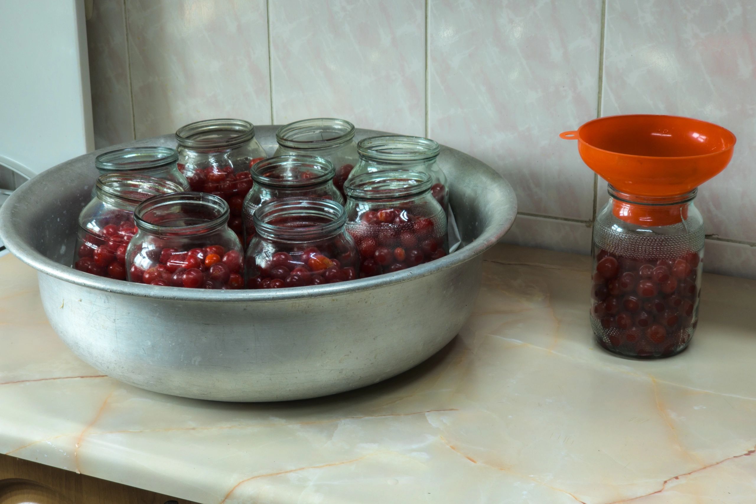 Glass jars on a kitchen countertop during preserving prep